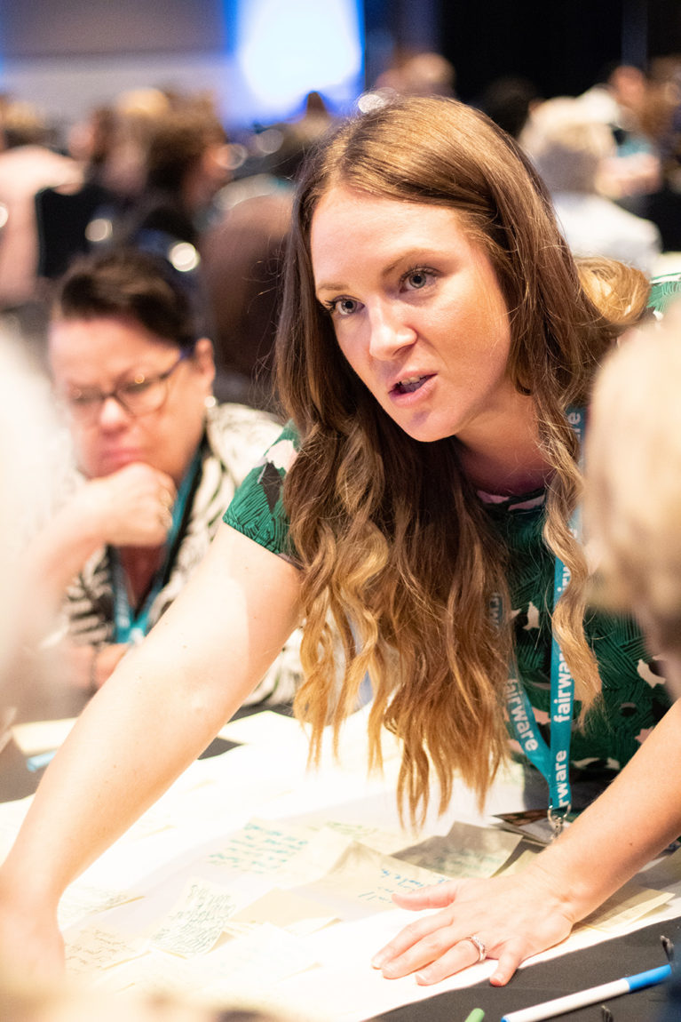 woman speaking across table at conference event