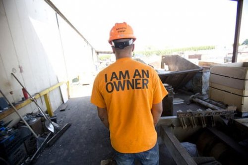 Image of employee in hardhat with shirt that says 