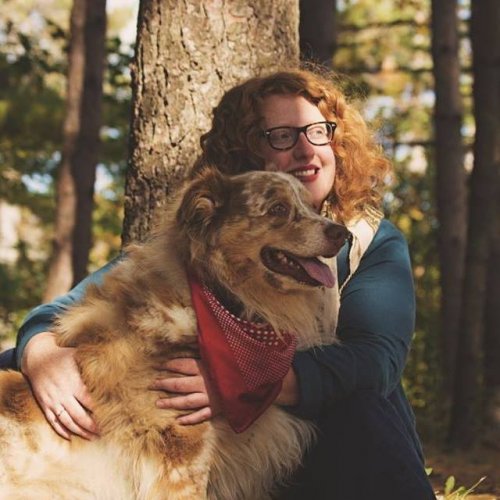 Katie Allen, in front of a tree with a dog